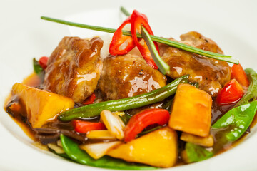 meat and vegetables  in sour and sweet sause on white background