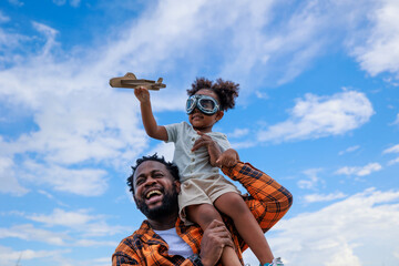 A daughter sitting on her father shoulder having a good time together. 