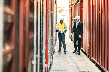 Container operator holding a walkie talkie to give instruction to other team member working in container yards.