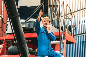 Container operator holding a walkie talkie to give instruction to other team member working in container yards.