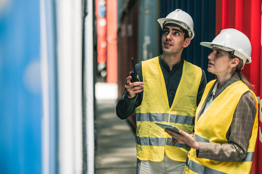 Container operator holding a walkie talkie to give instruction to other team member working in container yards.