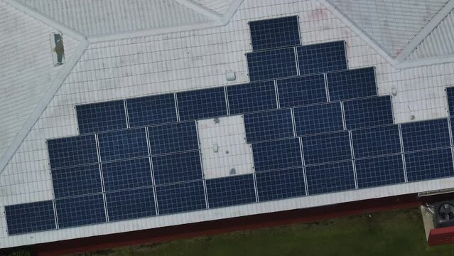 Aerial view of typical american building roof with rows of blue solar photovoltaic panels for producing clean ecological electric energy. Renewable electricity with zero emission concept