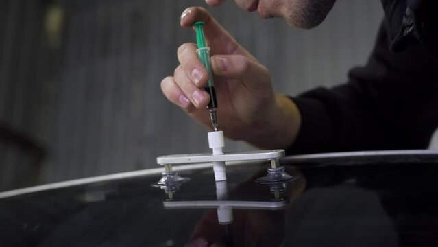 Filling a Crack with Adhesive on an Automotive Glass