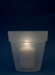 concept energy cuts, DIY lamp, pot and candle indoors, on the desk, dark blue background