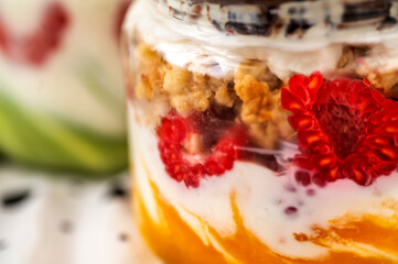 Detail of 2 jar with yogurt, granola, raspberry and mango.