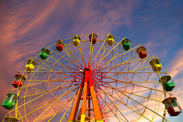 Attraction (carousel) ferris wheel against the background of a romantic evening sky