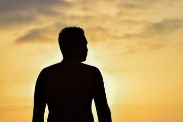 Silhouette of a man from behind at sunset
