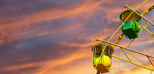 Attraction (carousel) ferris wheel against the background of a romantic evening sky