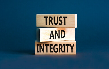 Trust and integrity symbol. Concept words Trust and integrity on wooden blocks. Beautiful grey table grey background. Business, psychological and trust and integrity concept. Copy space.