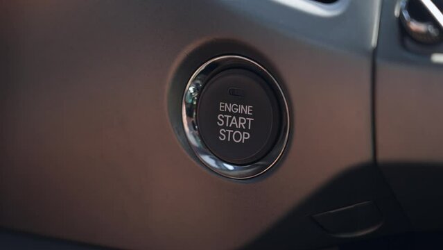 Push the engine start button in a car close up