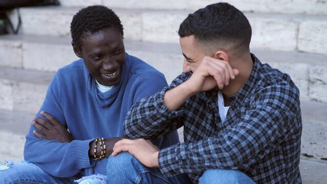 Two African friends from different cultures talk and laugh in the city center