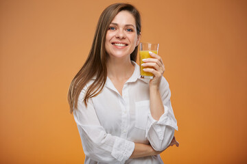 Smiling woman wearing white shirt holding orange juice glass. Isolated female advertising portrait.