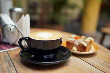 Cappuccino coffee and a carrot cake on a table in a cafe in Sucre, Bolivia. 