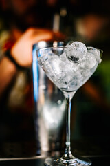 Ice cube in an empty glass on a bar counter in bar or pub