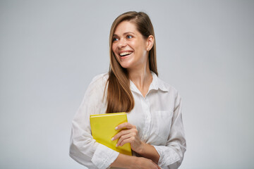 Teacher woman looking at left side holding yellow book, isolated female portrait. - 537838984