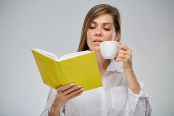 Student girl holding open yellow book and white coffee cup. Isolated advertising portrait.