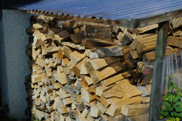 Firewood stacked in piles outside house
