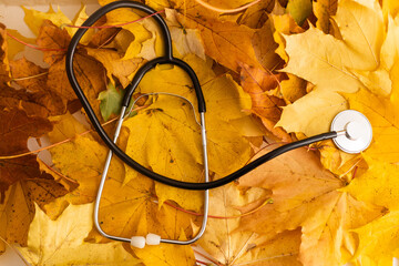 Background image with stethoscope on yellow autumn leaves - Powered by Adobe