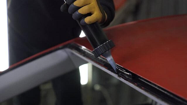 Car windshield installation. Application of Glass Glue. Close-up