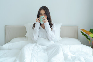 Beautiful girl sitting and drinking hot tea in the morning.