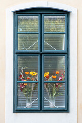 Window of a romantic and colorful house with flower pots.