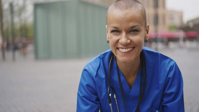Cinematic footage representation of the daily life of a nurse going to work at the hospital. Young doctor with shaved head and modern look. 
