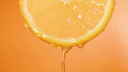 a slice of orange, water dripping on it, slow motion video - Powered by Adobe