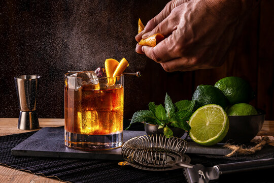 barman main pr&eacute;parant un cocktail