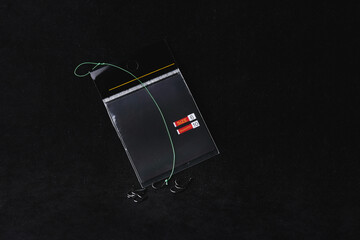 Fishing hook package on a black background. trap, catch on, risk. Business concept idea