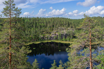 View from Hauklamminvuori Hill to the Hauklampi lake, rocks and forest in the Repovesi National Park on sunny summer day