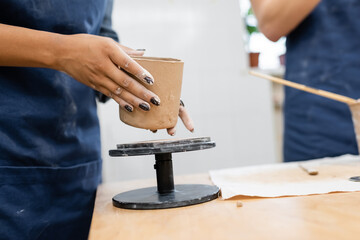 Cropped view of african american woman holding clay product in pottery studio.