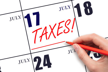 Hand drawing red line and writing the text Taxes on calendar date July 17. Remind date of tax...