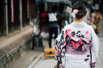 Fototapeta premium Young women wearing traditional Japanese Kimono with colorful maple trees in autumn is famous in autumn color leaves and cherry blossom in spring, Kyoto, Japan.