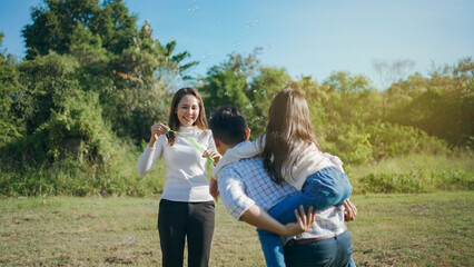 Happy asian family in the garden They are having fun playing and blowing bubbles. and enjoyed ourselves together in the green garden. Family enjoying sunny fall day in nature.