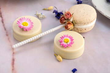 table of sweet products of fine pastry with macarons alfajores chocolate dipped cookies muffins donuts and cakes decorated with natural dry edible flowers