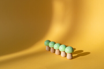 Wooden mushrooms on a cream-colored background. Copy space.