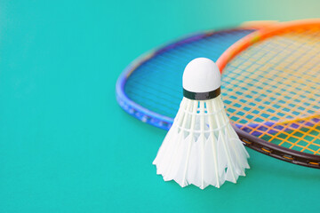 white shuttlecock on green background blurred badminton racket background. soft and selective focus.