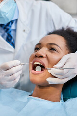 African American woman during dental procedure at dentist's office.