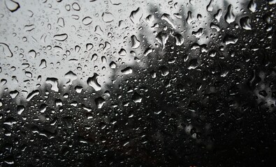 Monochrome shot of the rain droplets on a window