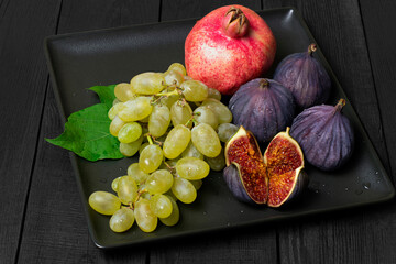 Autumn fruit plate with grapes, pomegranate and figs