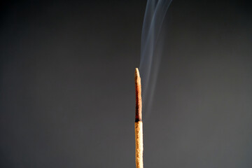 Close-up of illuminated smoke of incense stick against black background. Photo taken October 13th,...