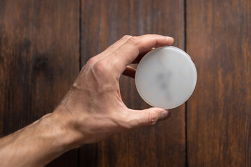 a man holds a led lamp in his hands on a dark background