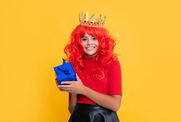 positive child in queen crown with present box on yellow background
