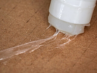 Close-up of using a glue stick on cardboard, handy glue for office and home crafts