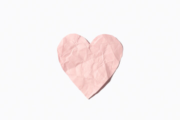 Pink crumpled paper heart isolated on white background