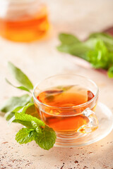 Sage mint herbal tea in a glass cup with fresh  leaves on wooden background. Natural medicine and healthy  herbs concept. Copy space