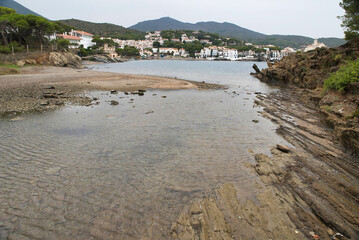 Fototapeta na wymiar Seascape the village of Cadaqués, near Barcelona. Picturesque old town with a beautiful beach. Isolated fishing village in the mountains. Famous tourist destination on the Costa Brava with the landmar