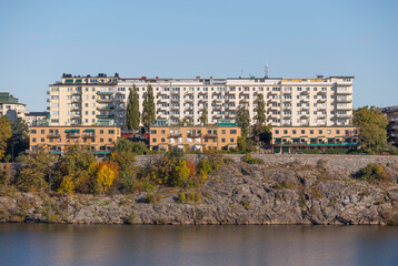 Fototapeta na wymiar Apartment houses on a cliff and a skyscraper a sunny a color full autumn day in Stockholm