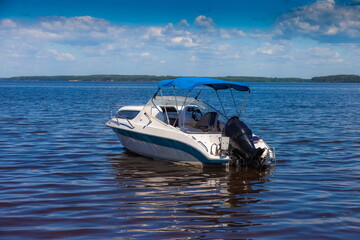 Fototapeta na wymiar Motor boat on a wide river in summer