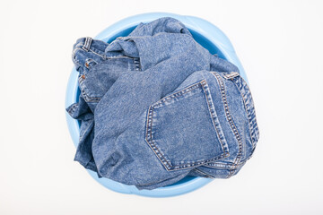 Jeans pants, denim in a bowl prepared for delicate hand washing, laundry concept